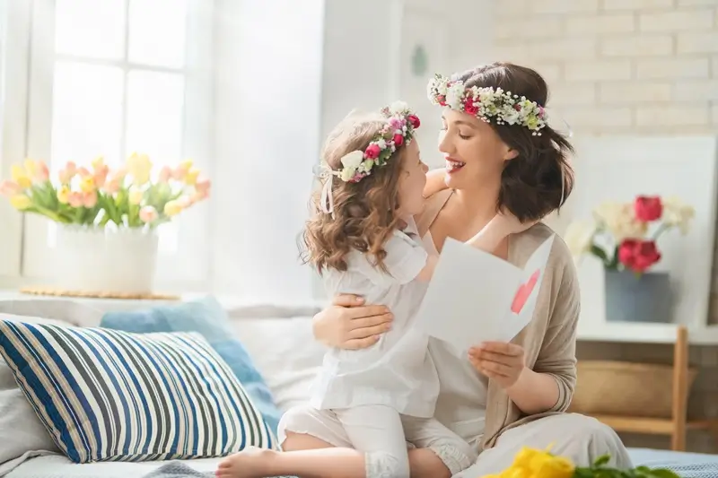 A mother and daughter in flower crowns celebrating Mother's Day.
