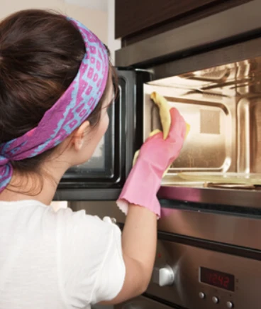 woman cleaning a microwave