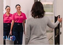 Molly Maid customer greeting two maids at her front door.