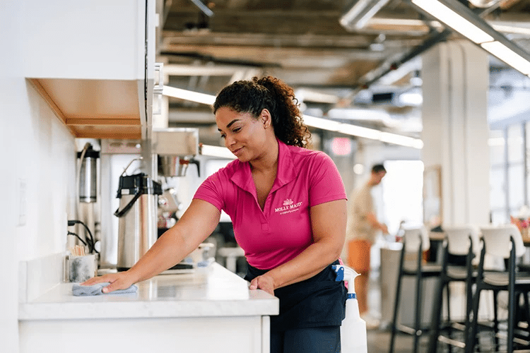 Molly Maid employee cleaning a small business office.