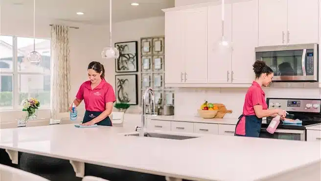 Pair of Molly Maid professionals cleaning a kitchen.