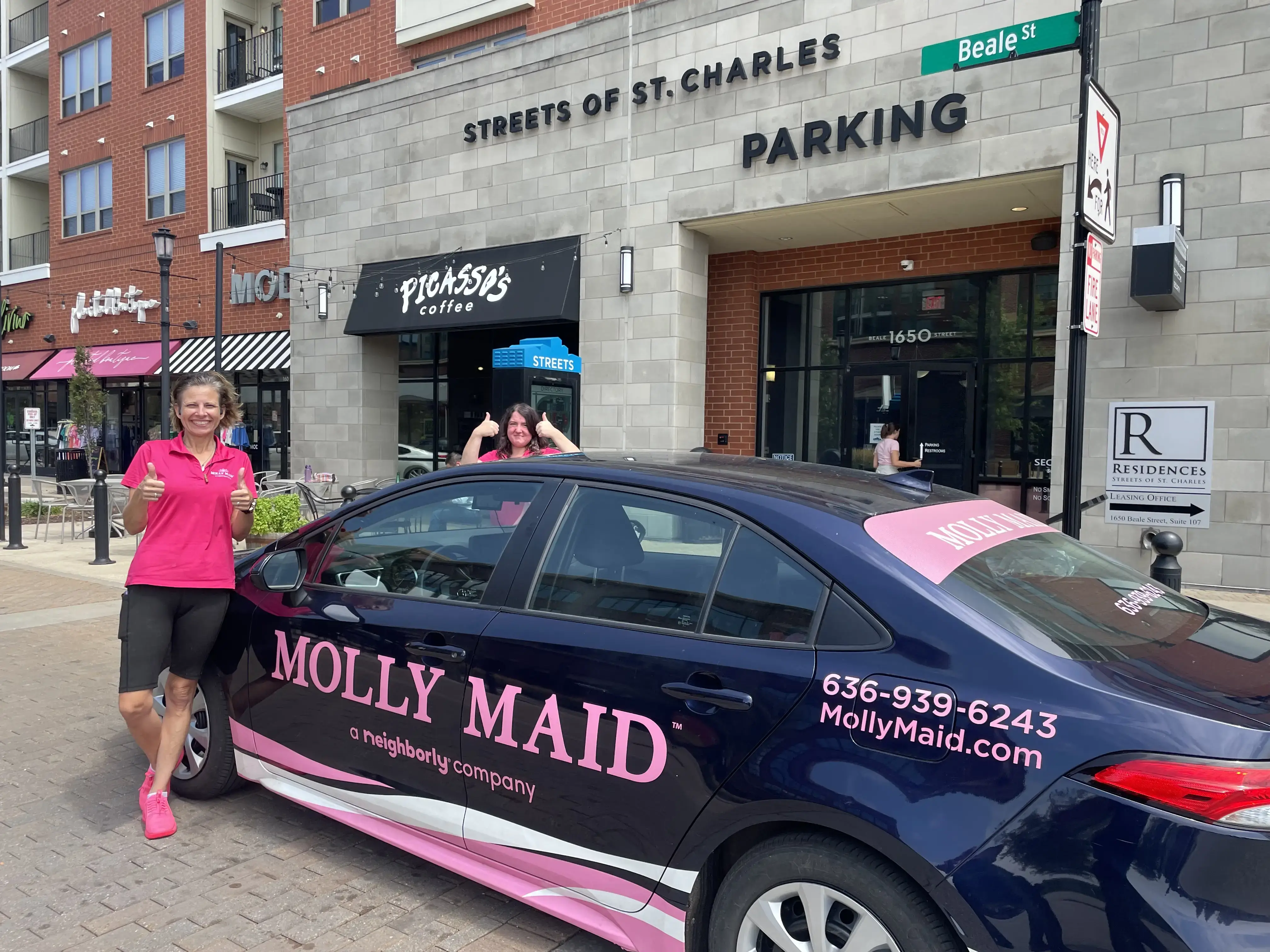 Molly Maid of St. Charles County house cleaning staff standing next to company car