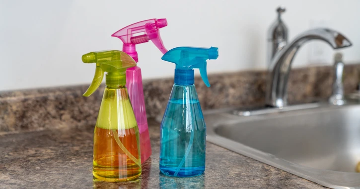 three homemade bathroom cleaners on a kitchen countertop