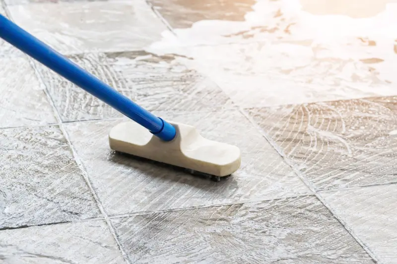 Tile floors being cleaned with a mop.