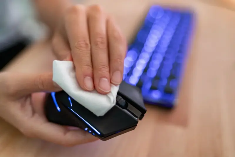 Disinfecting wipe on a computer mouse.