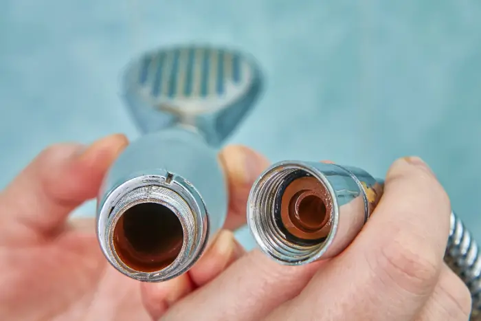 Person holding parts of a shower head