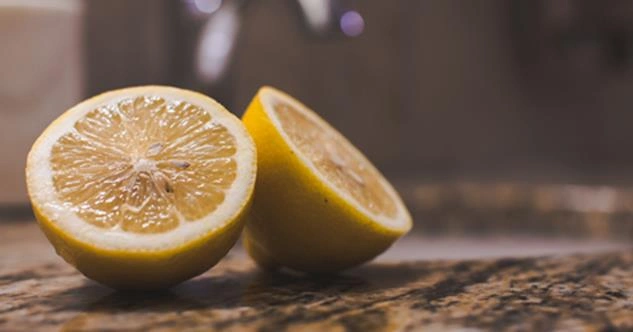 A lemon sliced into halves on a countertop