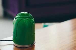 A small green humidifier on a wood table