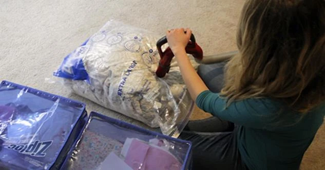 A woman vacuum-sealing clothes in space-saving storage bags