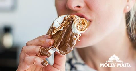 Woman eating messy chocolate dessert with her hand