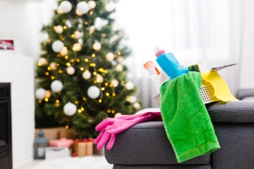 Cleaning supplies on sofa with Christmas tree in the background