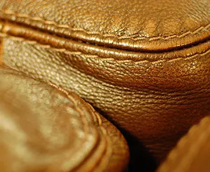 The seams of a brown leather couch