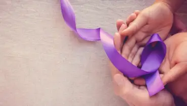 Hands holding Purple ribbons for domestic violence awareness