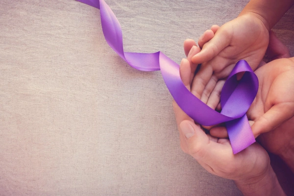 Hands holding Purple ribbons for domestic violence awareness