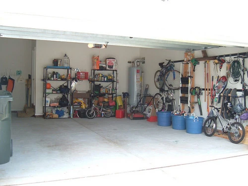 A neatly organized garage with bikes, storage units, and storage bins lining the perimeter