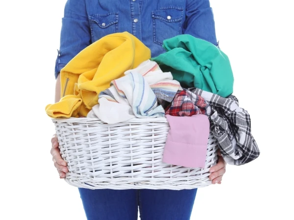 Woman holding a wicker basket full of laundry
