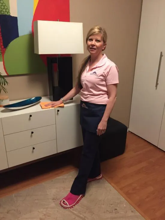Woman cleaning dresser wearing pink slippers