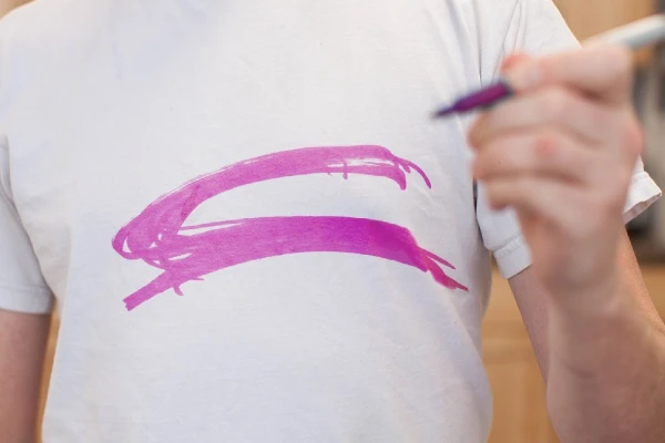 pink permanent marker on a white shirt.
