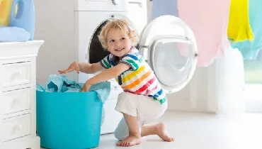 Kid helping with family chores in the laundry room