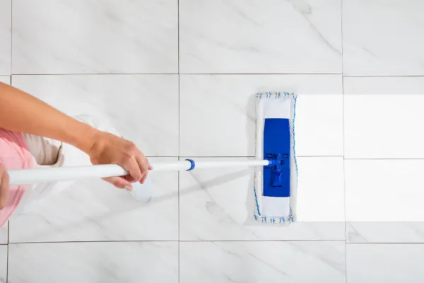 Overhead view of person cleaning a tile floor with a mop
