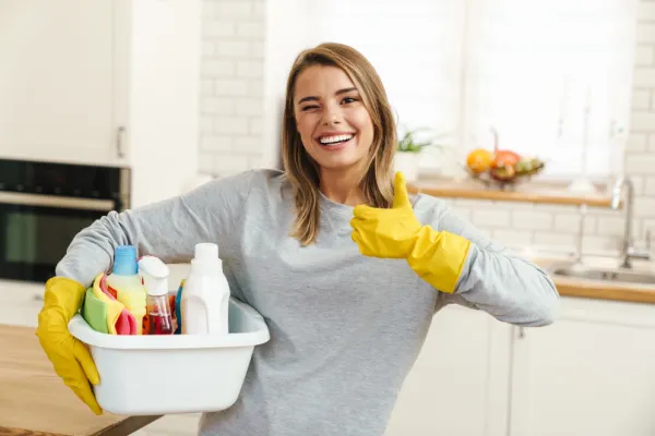 Woman holding thumbs up while cleaning