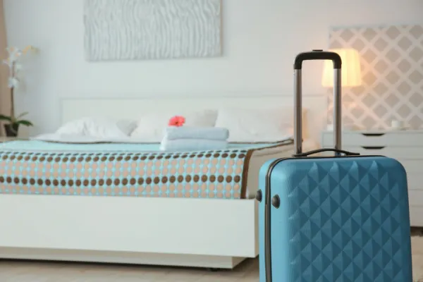 Blue suitcase in guest bedroom at home