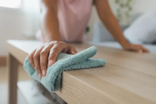 Woman cleaning and wiping the table with microfiber cloth