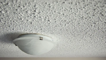 Popcorn ceiling with lighting fixture.