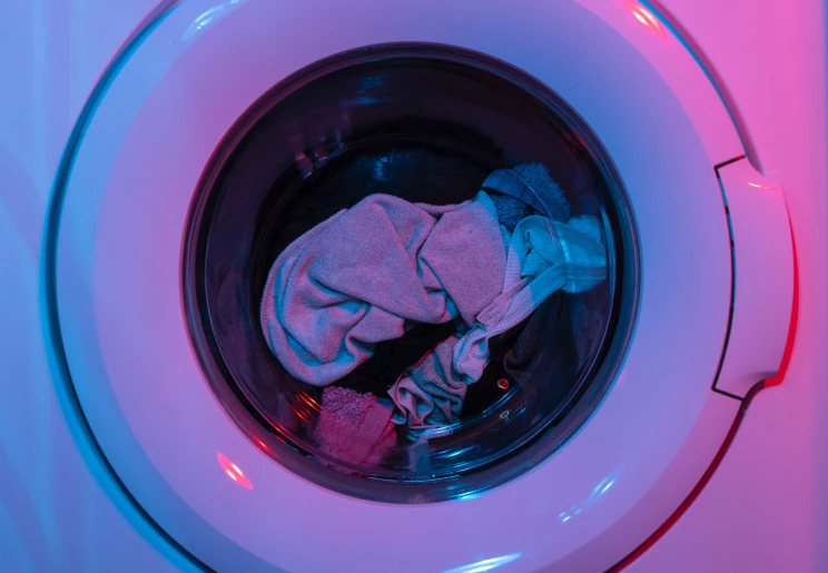 Clothes in a front-loading washing machine. Photo by engin akyurt on Unsplash.