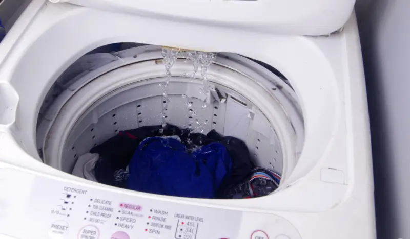 Clothes being washed in top-load washing machine.