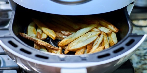 Overhead view of French fries cooked in an air fryer.