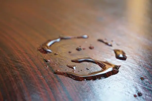 A ring shaped water stain on a wooden desk surface.