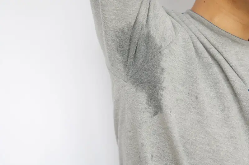 Man in gray shirt with sweat stains.