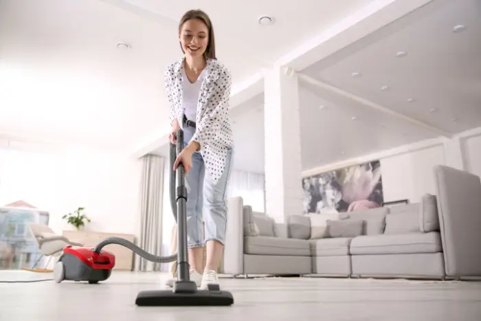 Woman vacuuming floor in her home