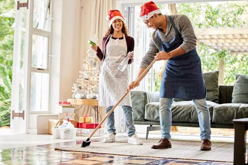 Couple Cleaning Holiday Themed Living Room