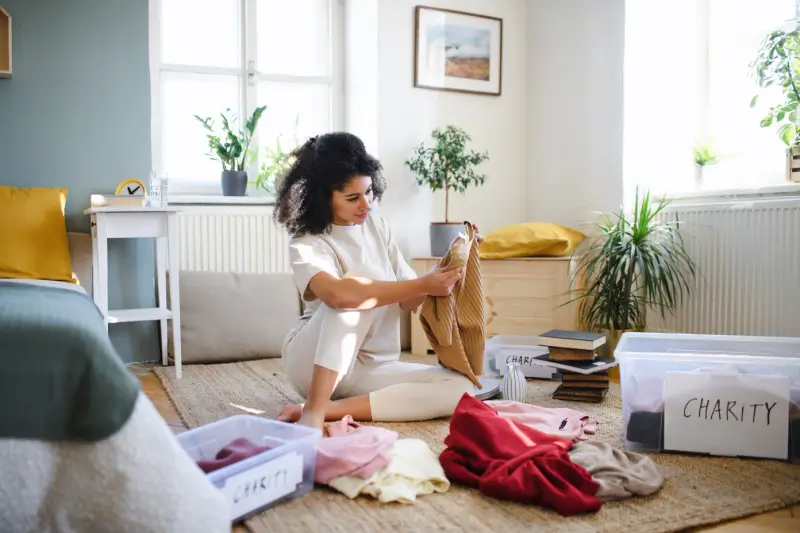 Woman sorting clothes in her living room