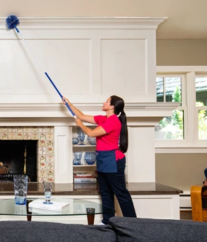 Woman dusting living room