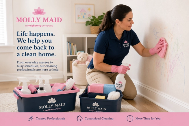 Molly Maid&reg; cleaning professional removing crayon marks from a painted wall using a soft cleaning cloth.