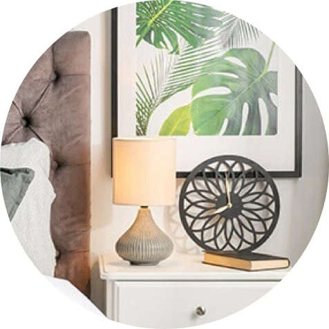 Decorated end table with lamp and wall hanging.