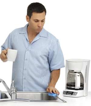 man cleaning a coffee maker.