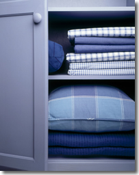 Neatly folded fitted sheets in a linen closet