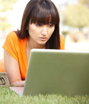 woman on laptop in the grass