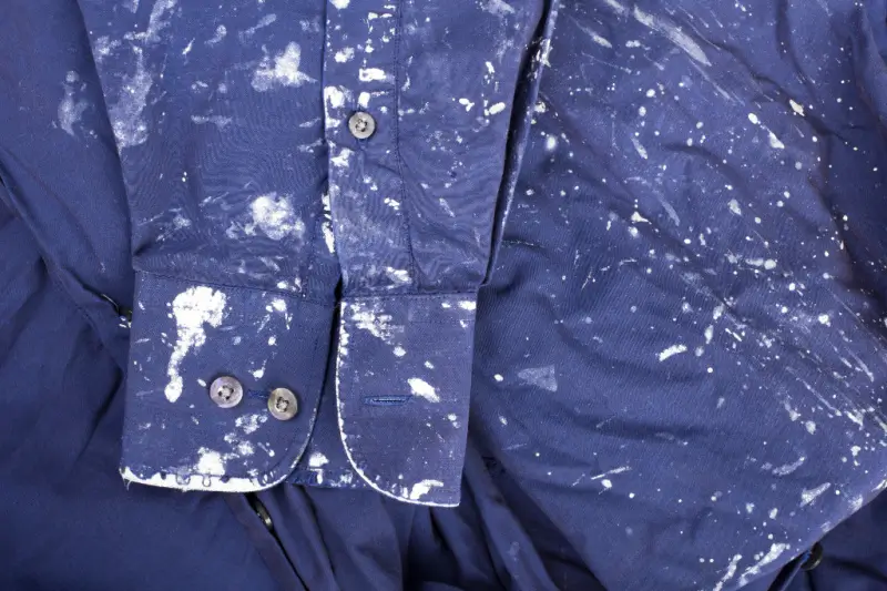 Paint stains on a blue shirt.