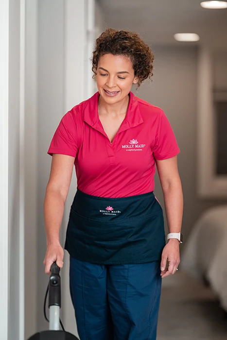 A Molly Maid professional vacuuming during a condo cleaning appointment in Tomball, TX. 
